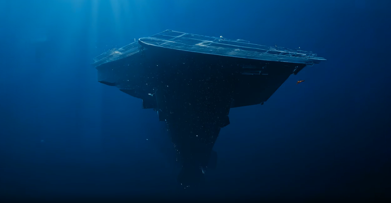 A massive ship holding still beneath the ocean, one small lit diver at its edge
